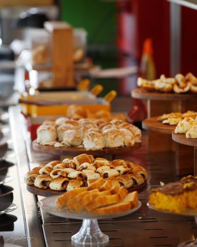 a bunch of pastries on plates on a table at Transamerica Executive Belo Horizonte in Belo Horizonte