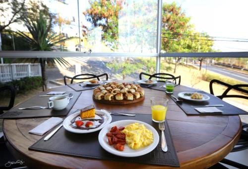 a wooden table with plates of breakfast food on it at Transamerica Executive Belo Horizonte in Belo Horizonte
