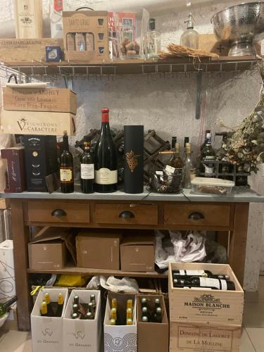 a shelf filled with bottles of wine and boxes at Domaine Spa Perret-3Ha-Château ArtDéco MasterSuite B&B ou Gîte de Charme-À3Mn Giverny-Jardins Monet-Le Vexin-Piscine Chauffée en Haute Saison-Aire Enfants-PingPong-Options Dîner-Billard-Massage-Yoga-Coaching-Fitness-Sauna-Hammam-Promo2Nuits Jacuzzi inclus in Sainte-Geneviève-lès-Gasny