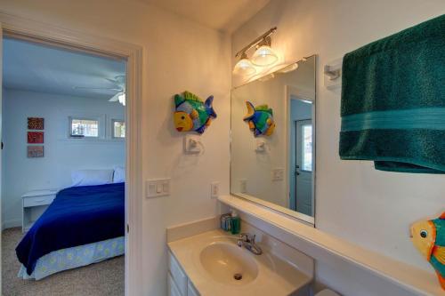 a bathroom with a sink and a mirror and a bed at Porch Song in Kitty Hawk