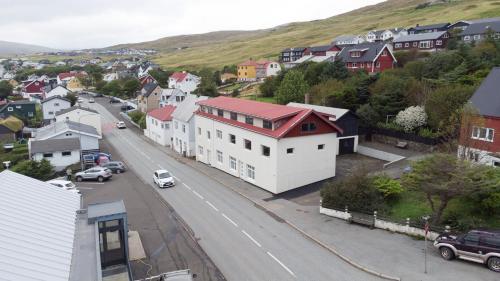 a small town with a white house and a street at Jotunheim / Aparthotel / Family Friendly in Miðvágur