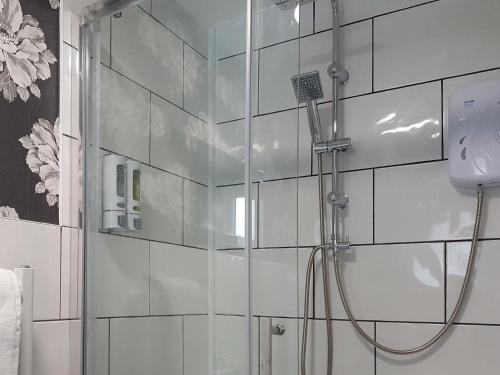 a shower in a bathroom with a glass wall at Cobblers Cottage in Dalton in Furness