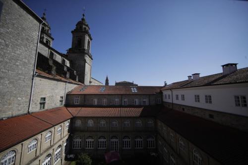 an old building with a clock tower in the distance at San Francisco Hotel Monumento in Santiago de Compostela