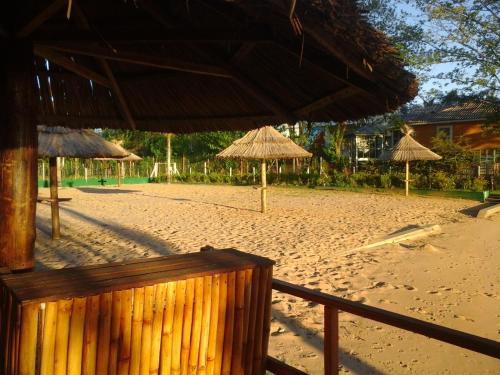 a beach with straw umbrellas on the sand at Cabañas Burdeos in Tigre