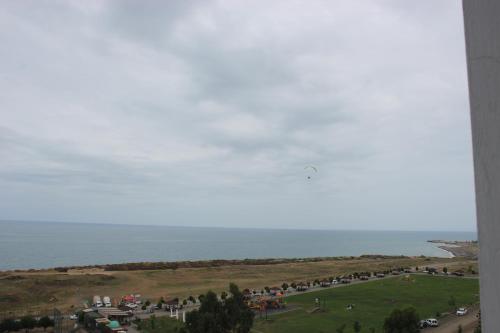 a group of people standing on a field near the ocean at New Akçaabat Hotel in Akcaabat