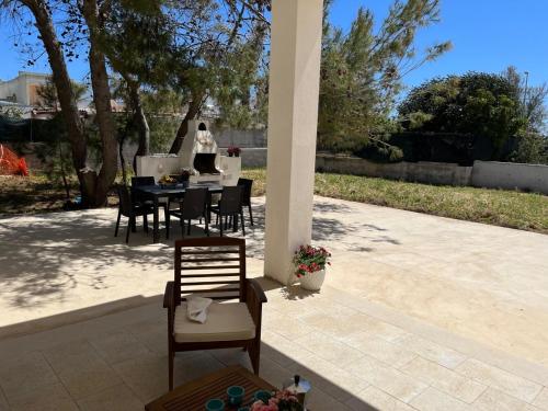 a patio with a table and chairs on a patio at QUASI NELL'ACQUA in Torre Pali 