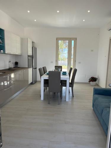 a dining room and kitchen with a table and chairs at QUASI NELL'ACQUA in Torre Pali 