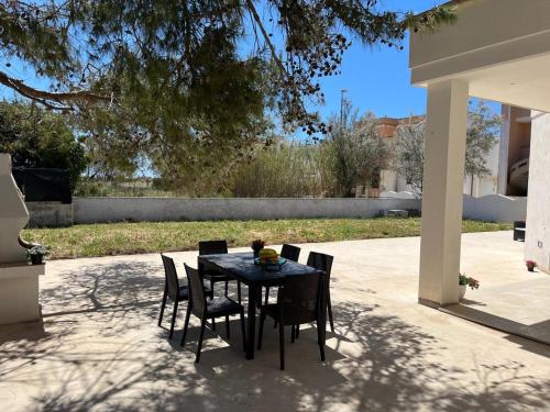 a black table and chairs on a patio at QUASI NELL'ACQUA in Torre Pali 