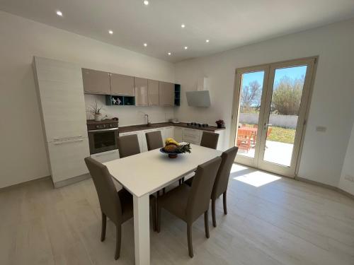 a kitchen and dining room with a table and chairs at QUASI NELL'ACQUA in Torre Pali 