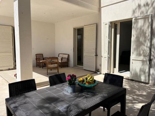 a table with a bowl of bananas on a patio at QUASI NELL'ACQUA in Torre Pali 