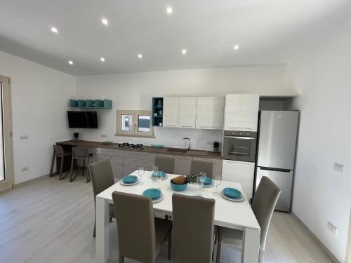 a kitchen with a white table and chairs in a kitchen at QUASI NELL'ACQUA in Torre Pali 
