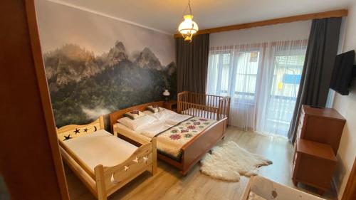 sypialnia z 2 łóżkami i obrazem na ścianie w obiekcie Helenówka - dom w stylu góralskim w mieście Szczawnica