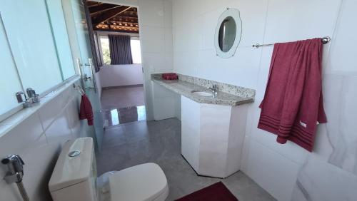 une salle de bain avec toilettes, lavabo et miroir dans l'établissement Tabatinga Relax Apartamento 2, à Conde
