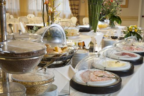 a buffet with plates and bowls of food on a table at Astoria Palace Hotel in Palermo