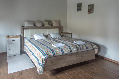 - une chambre avec un grand lit et du parquet dans l'établissement Hauptman apartman, à Nagyatád