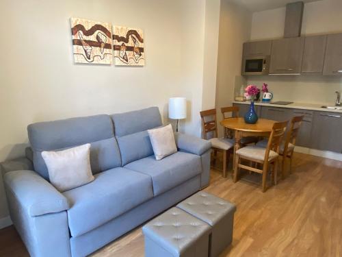 a living room with a blue couch and a table at SEVITUR Seville Comfort Apartments in Seville