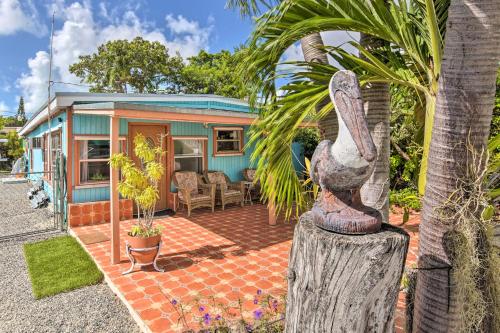 a blue house with a palm tree in front of it at Key Largo Home with Dock and Private Beach Access in Key Largo