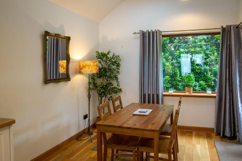 Un comedor con una mesa de madera y una ventana. en Luss Cottages at Glenview, en Luss