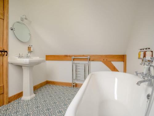 a bathroom with a tub and a sink at Hares Furrow - Uk12607 in Burton Overy
