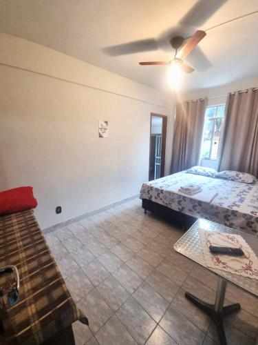 a bedroom with two beds and a ceiling fan at Pousada Regina in Cachoeiro de Itapemirim