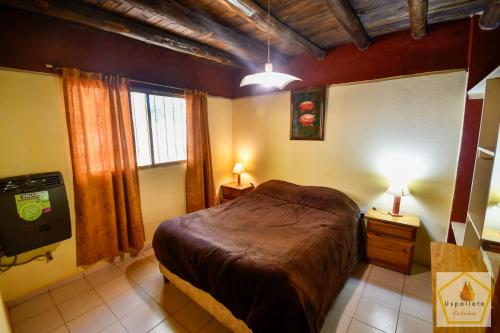 a bedroom with a bed and two lamps and a television at Cabañas Uspallata in Uspallata