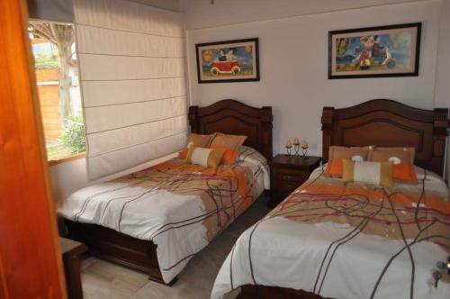1 dormitorio con 2 camas y ventana en Lujosa Quinta Vacacional Ibarra, en Ibarra