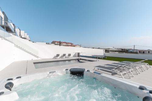 una piscina en la azotea de un edificio con sillas en Villa Carpe Diem, en Lourinhã