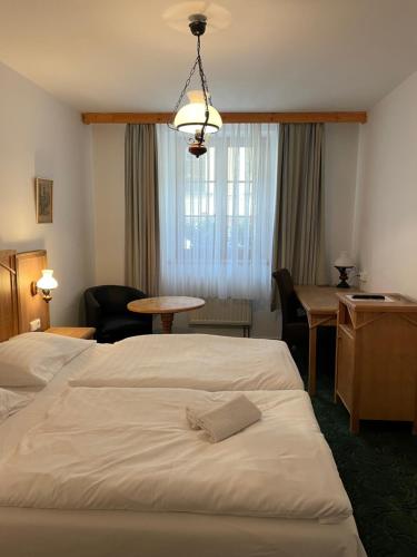 a hotel room with two beds and a table and a desk at Hotel Ennius in Klatovy