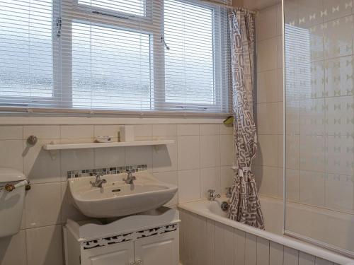 ein Badezimmer mit einem Waschbecken und einer Badewanne in der Unterkunft Cockleshell Cottage in Cockermouth