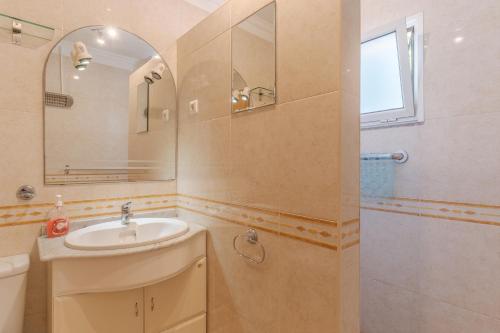 a bathroom with a sink and a mirror and a shower at Reis Magos Apartment by HR Madeira in Caniço