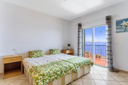 a bedroom with a bed and a view of the ocean at Reis Magos Apartment by HR Madeira in Caniço