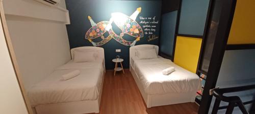 een kleine kamer met 2 bedden en een tafel bij Wifi 100Mbps+Netflix - Wau Bulan Flies @ The CEO in Bayan Lepas
