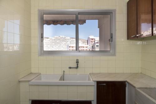 ein Bad mit einem Waschbecken und einem Fenster in der Unterkunft Montemar, B-9º-26 in Cullera