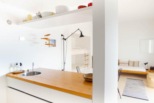 a kitchen with white walls and a wooden counter top at Beach hideaway apartment with modernist design in Santa Cruz de Tenerife