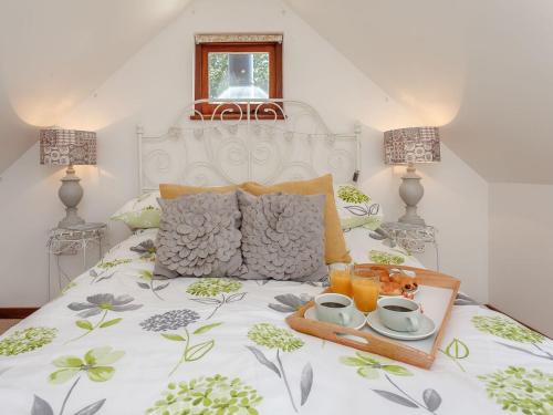 a bed with a tray of food and drinks on it at The Barn in Coldwaltham