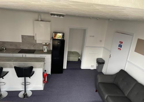 a kitchen and a living room with a couch at Apartments Azalea Terrace in Sunderland