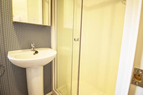 a bathroom with a sink and a shower at Beautiful Caravan With Decking At Azure Seas In Suffolk, Sleeps 6 Ref 32004az in Lowestoft