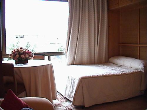 Habitación con cama, mesa y ventana en Apartment Plaza de Pradollano, en Sierra Nevada