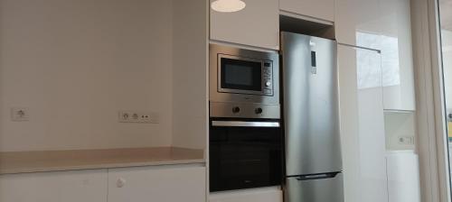 cocina con nevera de acero inoxidable y microondas en Casa Bayer, en Benicàssim