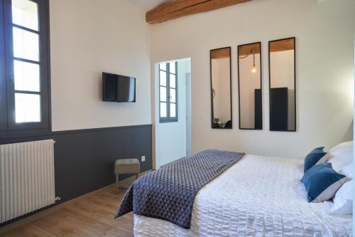 a bedroom with a bed and a tv on a wall at Clos Bernon in Libourne