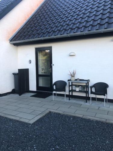 a patio with two chairs and a table next to a white building at A-Bed in Esbjerg