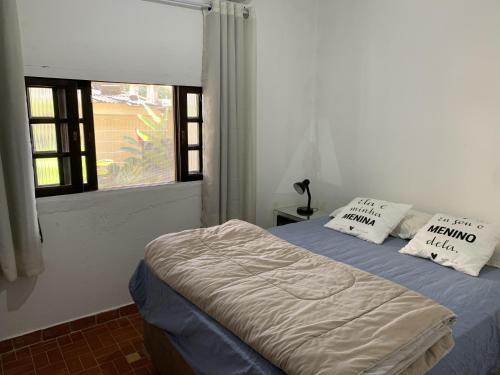 een slaapkamer met een bed met 2 kussens en een raam bij Chácara com Piscina, Churrasqueira, Salão de Jogos, Campo futebol in Itariri