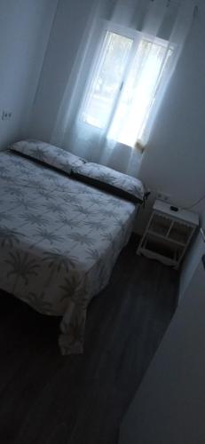Dormitorio pequeño con cama y ventana en Las súper noches, en Castellón de la Plana