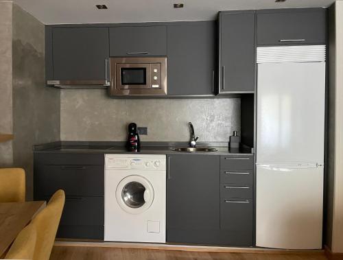 a kitchen with a washing machine and a microwave at VielhaTuca in Betrén