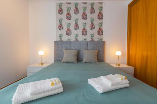 a bedroom with a bed with two towels on it at Secret Beach House in Água de Alto
