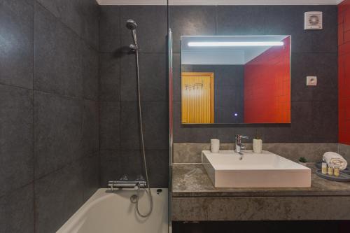 a bathroom with a sink and a tub and a mirror at Secret Beach House in Água de Alto
