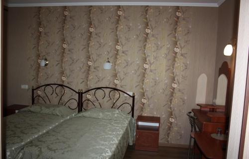 a bedroom with a bed and a curtain with flowers at Hotel Gostynnyi Dvir in Bucha