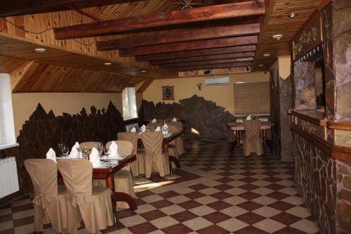 ブチャにあるHotel Gostynnyi Dvirのテーブルと椅子が備わるレストラン