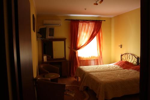 a bedroom with a bed and a window at Hotel Gostynnyi Dvir in Bucha
