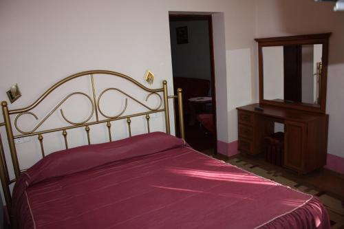 a bedroom with a bed and a dresser and a mirror at Hotel Gostynnyi Dvir in Bucha